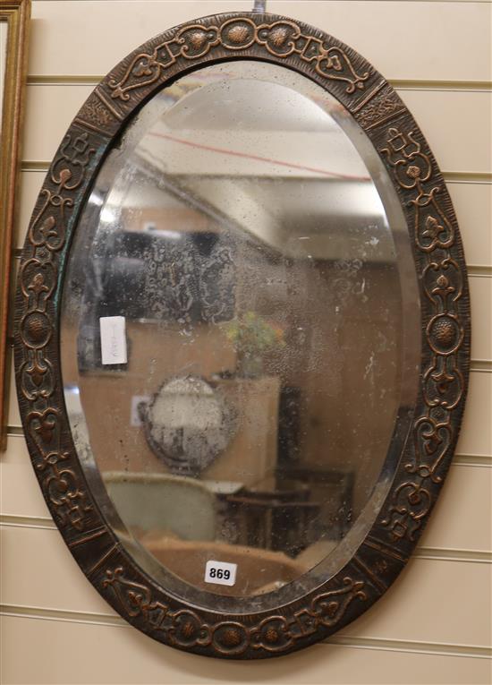 An embossed copper oval mirror W.49cm